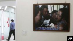 A picture of the reunion of family members from North and South Korea in 2010 is displayed at the headquarters of the Korea Red Cross in Seoul, South Korea, Jan. 7, 2014. 