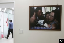A picture of the reunion of family members from North and South Korea in 2010 is displayed at the headquarters of the Korea Red Cross in Seoul, South Korea, Jan. 7, 2014.
