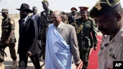 The President of the Republic of Sudan Omar al-Bashir, center, is escorted by Salva Kiir Mayardit, the Vice President of the Republic of Sudan, left, as he arrives at the airport in the southern Sudanese capital of Juba, 04 Jan 2011