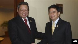 Indonesian President Susilo Bambang Yudhoyono, left, shakes hands with Thai Prime Minister Abhisit Vejjajiva before their trilateral meeting with Cambodia in Jakarta, Indonesia, May 8, 2011