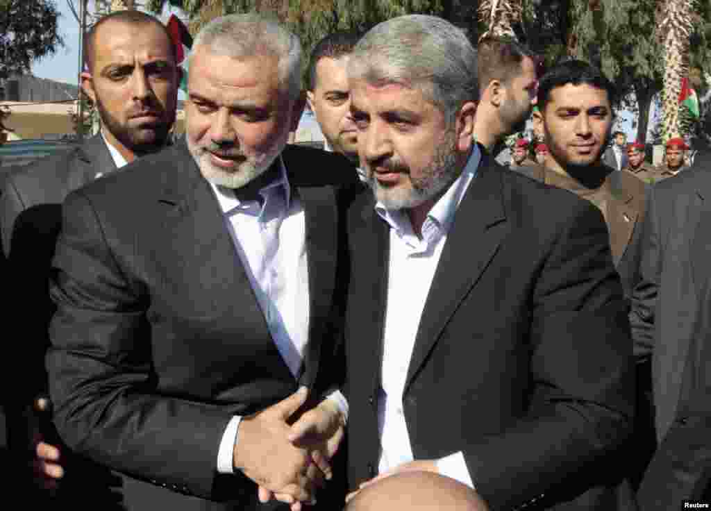 Hamas chief Khaled Meshaal (front R) walks with senior Hamas leader Ismail Haniyeh (front L) upon his arrival at the Rafah crossing in the southern Gaza Strip, December 7, 2012. 