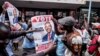 Supporters of Zimbabwean opposition MDC Alliance party leader Nelson Chamisa hold his campaign posters as they gather outside the MDC Alliance's headquarters in Harare on July 31, 2018.