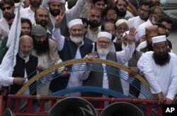 FILE - The leader of Hizbul Mujahideen, Syed Salahuddin, second left front, and the head of Jamaat-e-Islami, a Pakistani religious party, Sirajul Haq, third left front, and others lead an anti-Indian rally in Lahore, Pakistan, July 31, 2016.