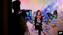 In this Thursday, Aug. 22, 2019 photo, Karishma Naz, music presenter on Zan TV records for a show, in Kabul, Afghanistan. (AP Photo/Rafiq Maqbool)