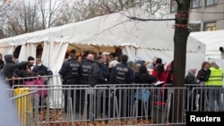 Migrants line up at the compound outside the Berlin Office of Health and Social Affairs (LAGESO) waiting to register in Berlin, Germany, Nov. 17, 2015. 