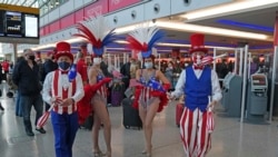 Performers entertain passengers at London Heathrow Airport's T3 as the US reopens its borders to UK visitors in a significant boost to the travel sector, in London, Monday, Nov. 8, 2021. (Steve Parsons/PA via AP)