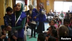 FILE - Syrian refugee children play as they wait with their families to register their information at the U.S. processing center for Syrian refugees in Jordan, in Amman, Jordan, April 6, 2016.