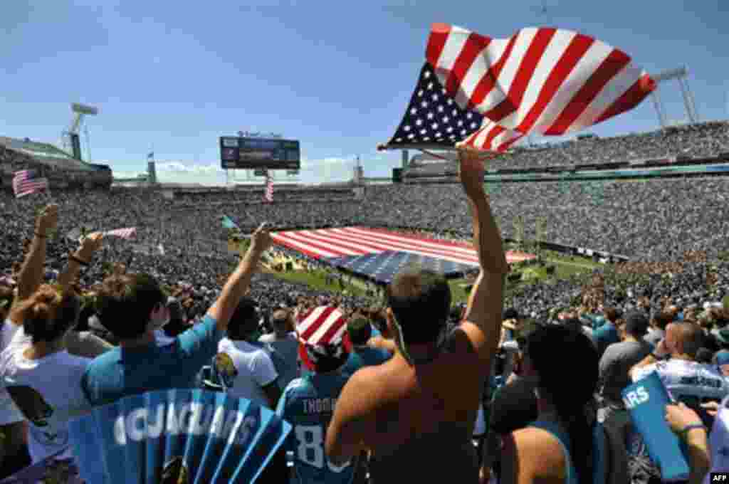 Fans cheer during a ceremony in commemoration of the 10th anniversary of the 9/11 terrorist attacks before an NFL football game between the Jacksonville Jaguars and the Tennessee Titans, Sunday, Sept. 11, 2011, in Jacksonville, Fla. (AP Photo/Stephen Mort