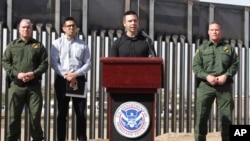 FILE - Customs and Border Protection Commissioner Kevin McAleenan, center, announced that the Trump administration will temporarily reassign several hundred border inspectors during a news conference at the border in El Paso, Texas, March 27, 2019. 