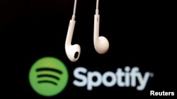 ARCHIVO - Audífonos y logo del servicio musical en línea Spotify. 