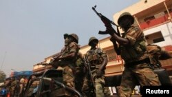 Central African Republic soldiers brandish their weapons as they follow President Francois Bozize's convoy heading for the airport in Bangui for peace talks in Gabon January 10, 2013.