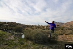 Enrique Morones, founder and director of the human rights organization Border Angels, leaves a bottle of water for dehydrated migrants in the Southern California desert. (R. Taylor/VOA)