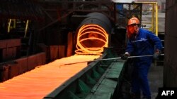 A Chinese employee sorts hot red steel at a steel plant in Zouping in China's eastern Shandong province on March 5, 2018.