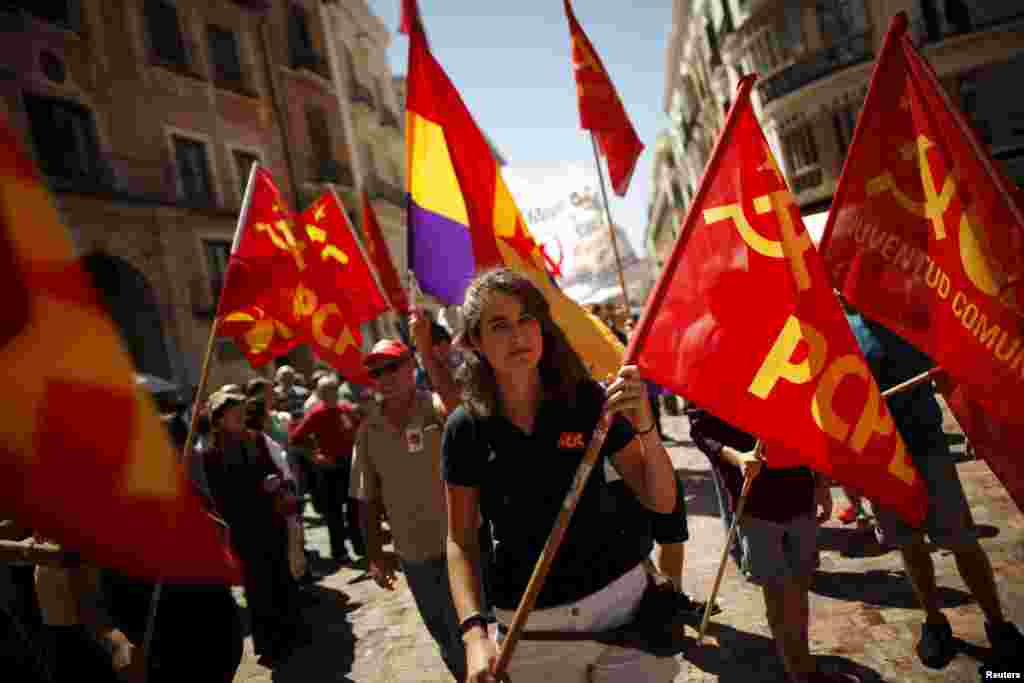 Dân chúng cầm quốc kỳ Tây Ban Nha (giữa) và cờ Cộng sản trong cuộc mít tinh vào ngày Quốc tế Lao động 1 tháng 5 ở Malaga, Tây Ban Nha.