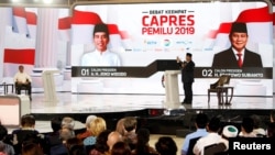 Capres 02 Prabowo Subianto berbicara sementara Capres 01 Joko Widodo mendengarkan pada acara debat Sabtu malam (30/3) di Jakarta.
