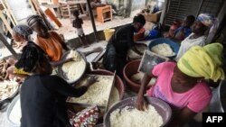 Les femmes préparent la semoule de manioc pour la préparation du plat d'accompagnement attiéké à Abidjan, le 22 mai 2018.