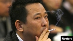 FILE - Liu Han, former chairman of Hanlong Mining, smokes during a conference in Mianyang, Sichuan province.