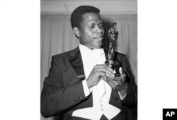 Actor Sidney Poitier poses with his Oscar for best actor for "Lillies of the Field" at the 36th Annual Academy Awards in Santa Monica, California, on April 13, 1964.
