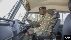 FILE - A Zambian army soldier is seen inside a military truck as other patrol the Chawama Compound in Lusaka on Aug. 3, 2021.