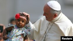 El Papa Francisco bendice a una niña