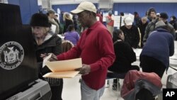 A poll worker assists a voter arriving from a relocated polling site that closed after flooding from superstorm Sandy on Manhattan's Lower East Side in New York, November 6, 2012.