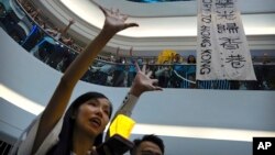 Demonstran menyanyikan lagu tema yang ditulis oleh pengunjuk rasa "Glory to Hong Kong" di pusat perbelanjaan Times Square di Hong Kong, Kamis, 12 September 2019. (Foto: AP)