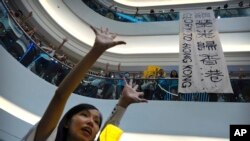 FILE - Demonstrators sing a theme song written by protestors "Glory to Hong Kong" at the Times Square shopping mall in Hong Kong, Sept. 12, 2019. 