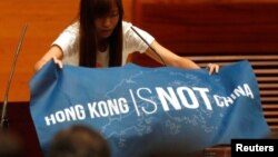 香港立法会新一届非建制派议员在就职宣誓仪式上展示出用英文写的“香港不是中国”的蓝色旗帜（2016年10月12日）