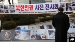 FILE - A man looks at photos showing North Korean children suffering from famine at an exhibition in Seoul, South Korea, Feb. 27, 2014.