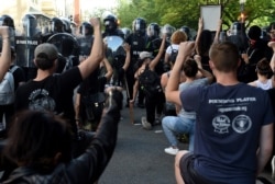 Protesters kneel and hold up their hands in front of a row of police during a demonstration against the death of George Floyd at a park near the White House on June 1, 2020 in Washington.