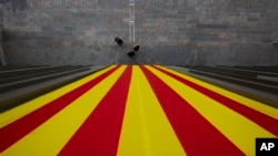 FILE - A Catalan flag hangs from a Catalan government building in Girona, Spain.