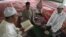 A Muslim man from the Chinese Hui minority reads the Koran as others listen in a sitting room in Aksu, Xinjiang Uighur Autonomous Region, July 27, 2012.