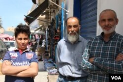 Abdullah, center, and his cousin Mohammed, right, run a shoe store in a Tripoli market, May 2, 2019. They say that since the war began in early April, Tripoli has become poorer, more crowded and scared. (H.Murdock/VOA)