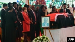 Family and friends stand near the flag-draped coffin of former Kenyan President Mwai Kibaki as he lies in state during a memorial service at the Nyayo National Stadium in Nairobi, April 29, 2022.
