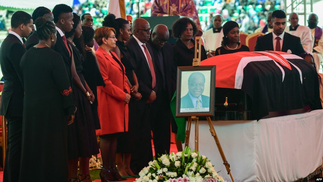 Family and friends stand near the flag-draped coffin of former Kenyan President Mwai Kibaki as he lies in state during a memorial service at the Nyayo National Stadium in Nairobi, April 29, 2022.
