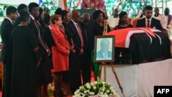 Family and friends stand near the flag-draped coffin of former Kenyan President Mwai Kibaki as he lies in state during a memorial service at the Nyayo National Stadium in Nairobi, April 29, 2022.
