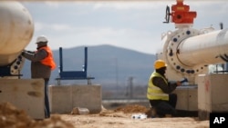 FILE - Men work on a new pipeline near Komotini, northern Greece, March 21, 2022. Crossing a remote border area of Greece and Bulgaria, the pipeline will help countries in the region dependent on Russian imports gain greater access to the global natural gas market.