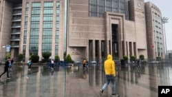 FILE - People walk outside the Justice Palace, in Istanbul, Sept. 20, 2019. Two reporters for the U.S.-based Bloomberg news agency appeared in court on Friday accused of trying to undermine Turkey's economic stability with a story they wrote the year prior. 
