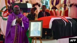 Un évêque bénit le cercueil drapé du drapeau de l'ancien président kényan Mwai Kibaki alors qu'il repose en état lors du service commémoratif au stade national de Nyayo à Nairobi le 29 avril 2022.