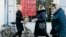 FILE - People walk past a currency exchange office screen displaying the exchange rates for the U.S. dollar and the euro to Russian rubles in Moscow, Feb. 28, 2022.