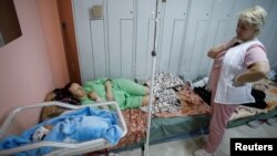 FILE - Patients take shelter in the basement of a perinatal center as air raid siren sounds are heard amid Russia's invasion, in Kyiv, Ukraine, March 2, 2022. 