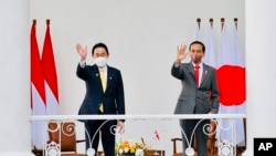 Japanese Prime Minister Fumio Kishida, left, and Indonesian President Joko Widodo, right, wave during their meeting at the presidential palace in Bogor, West Java, Indonesia, Friday, April 29, 2022. (Laily Rachev, Indonesian President Palace via AP)