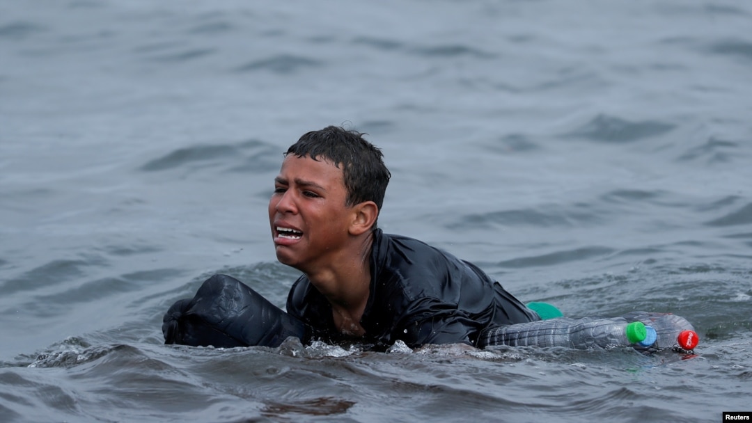 Achraf, 16, plače dok pliva koristeći flaše kao plovke, blizu ograde između špansko-marokanske granice, nakon što su hiljade migranata preplivale granicu, u Seuti, Španija, 19. maja 2021.