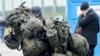 FILE - A man carries combat gear as he leaves Poland to fight in Ukraine, at the border crossing in Medyka, Poland, March 2, 2022. 