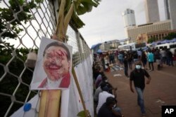 Potret Perdana Menteri Mahinda Rajapaksa yang dirusak terlihat di lokasi protes yang sedang berlangsung, di luar kantor presiden di Kolombo, Sri Lanka, 23 April 2022. (Foto: AP)