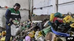 Le Kenyan Nzambi Matee, entrepreneur et inventeur, trie les déchets plastiques avant de les broyer, les mélanger avec du sable puis les recycler pour fabriquer des briques, dans l'atelier de l'entreprise dans la zone industrielle de Nairobi, le 16 février 2022.