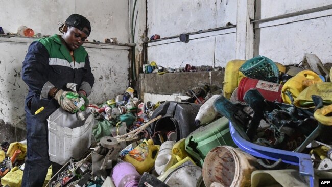 Le Kenyan Nzambi Matee, entrepreneur et inventeur, trie les déchets plastiques avant de les broyer, les mélanger avec du sable puis les recycler pour fabriquer des briques, dans l'atelier de l'entreprise dans la zone industrielle de Nairobi, le 16 février 2022.