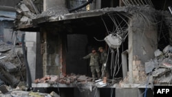 Miners check a damaged building following Russian strikes in Kyiv on April 29, 2022.