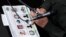 ARCHIVO - El jefe de la Policía Nacional de Colombia, el general José Roberto León, sostiene un documento policial que muestra las fotos de cuatro hombres que han sido capturados, durante una conferencia de prensa en la sede de la policía en Bogotá.