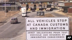FILE - This April 16, 2001 file picture shows a sign written in both English and French as vehicles approach the Canadian-U.S. border at Stanstead, Quebec, Canada. (AP Photo/Jon-Pierre Lasseigne)